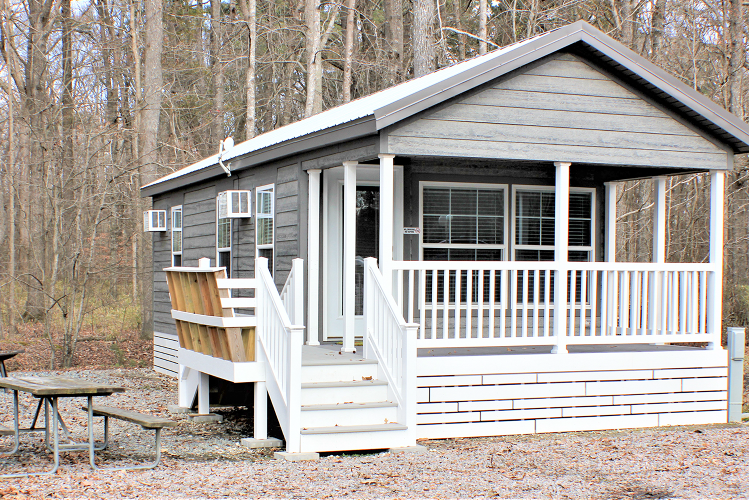 Cottage exterior, deck with seating, and picnic table.