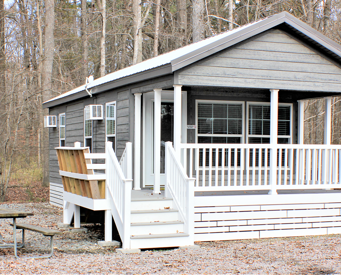 Cottage exterior, deck with seating, and picnic table.