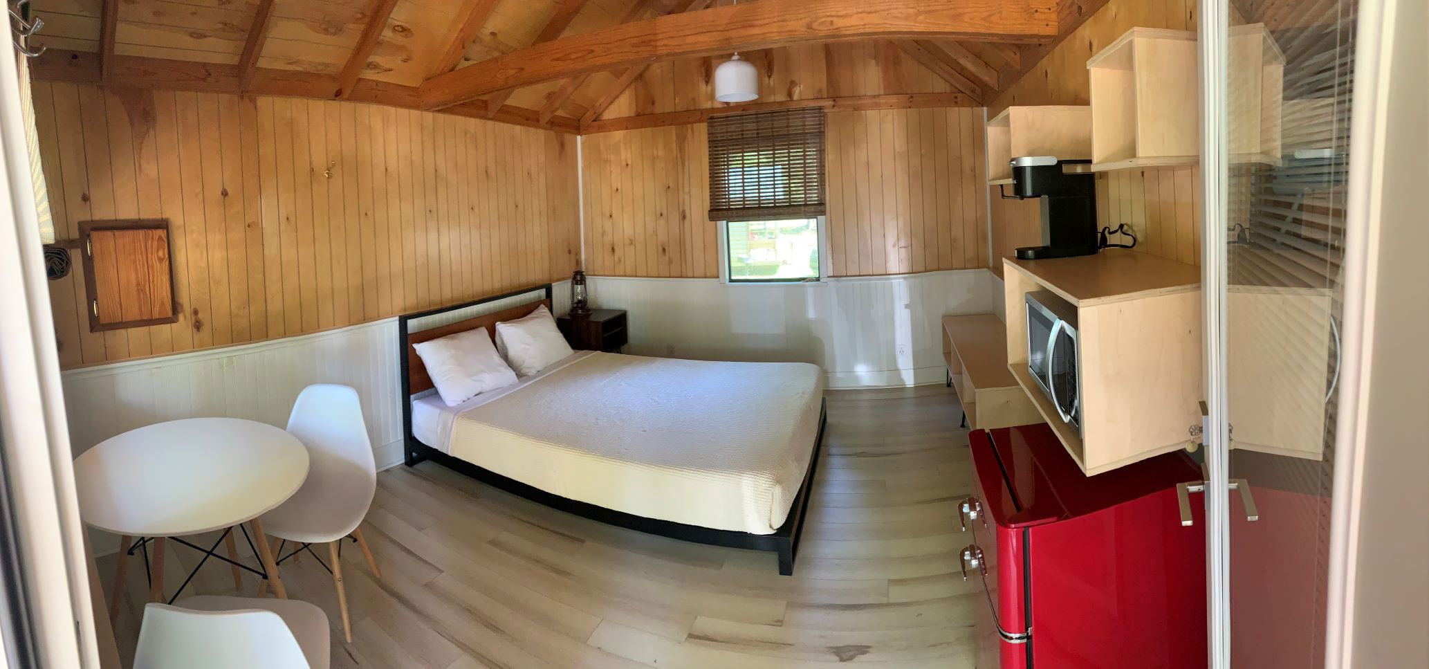 A studio cabin contains a queen size bed with linens provided and dining set for two.