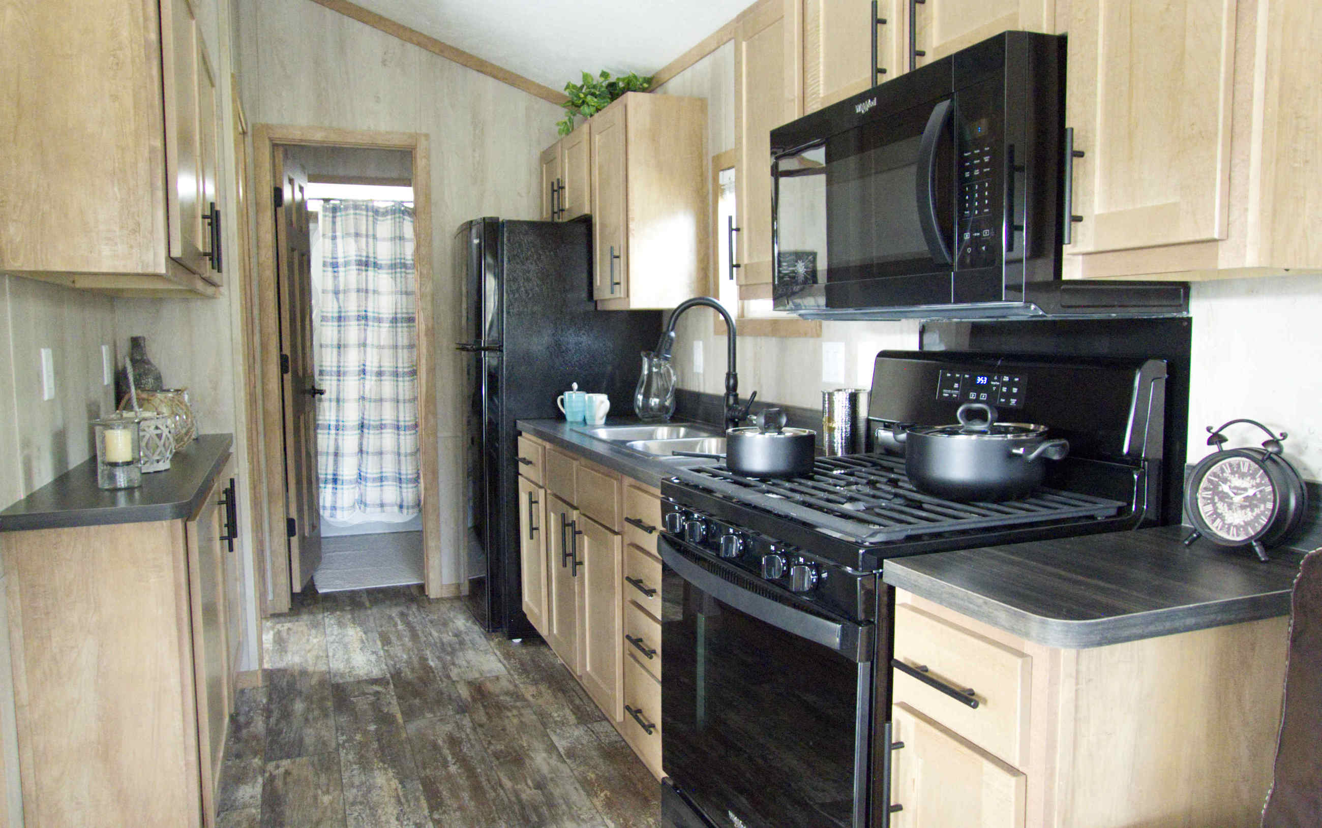 Cabinets with utensils, fridge-freezer, sink, microwave, 4 burner stove and oven, and coffee maker.