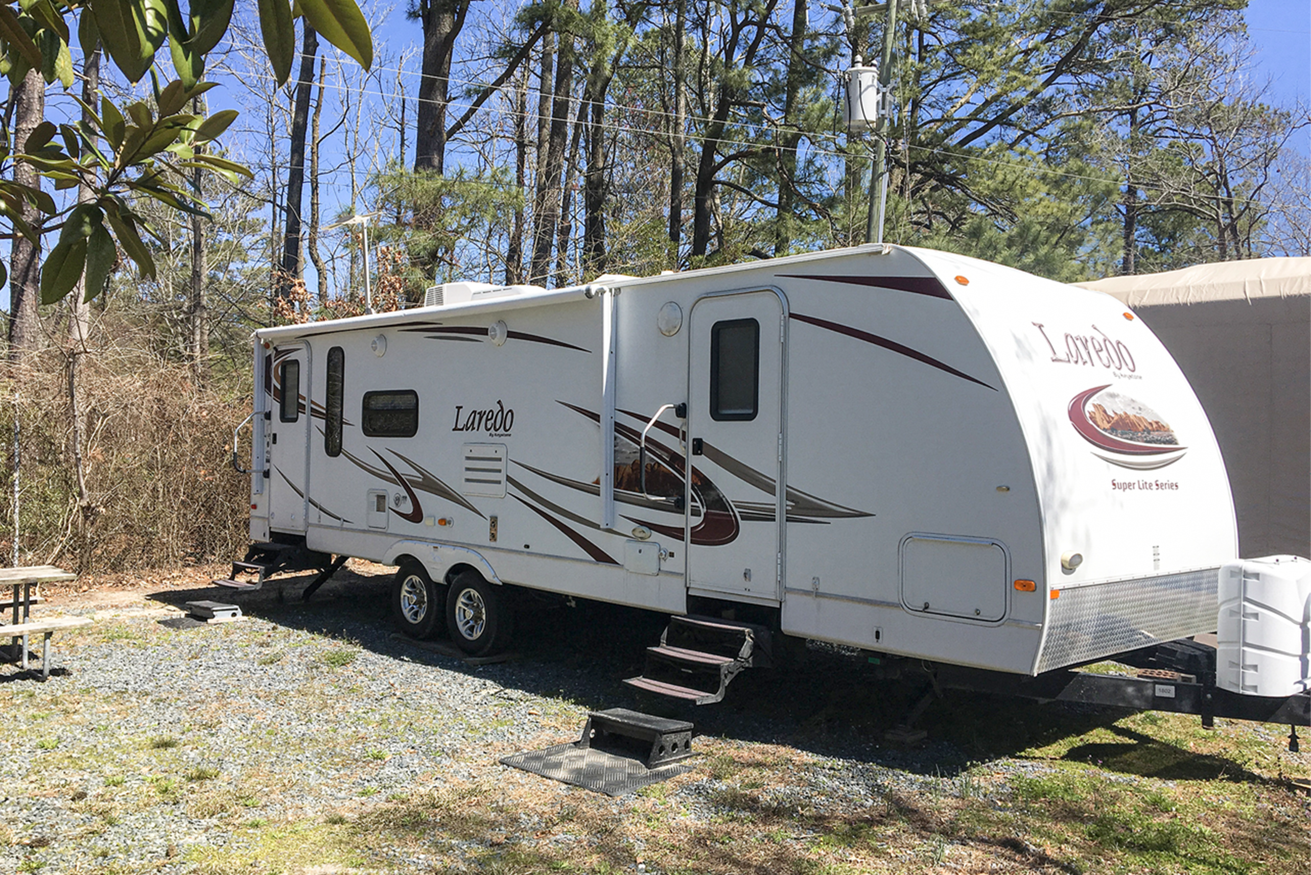Laredo's exterior with picnic table and firepit.