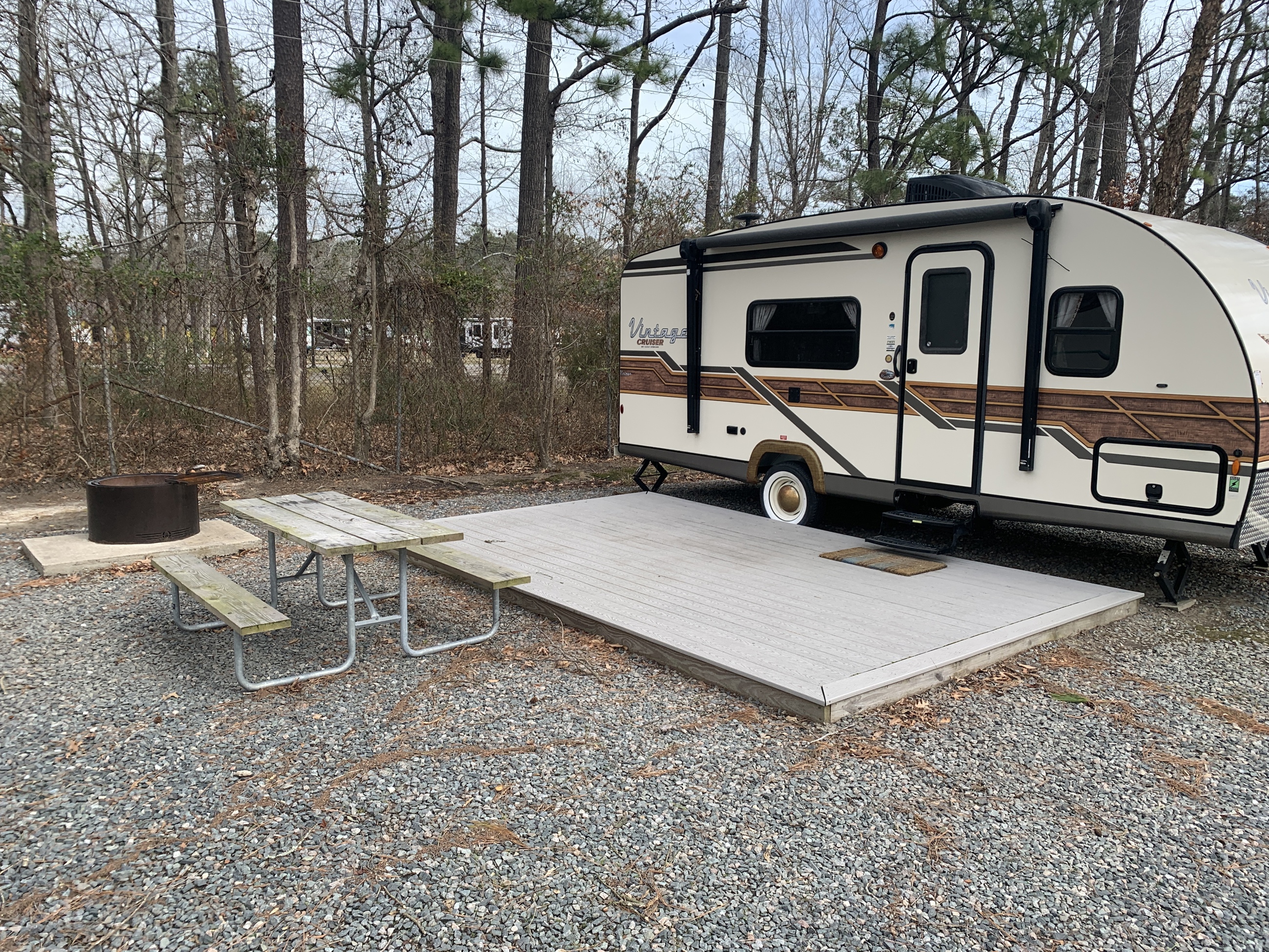 Rental trailers are equipped with a wooden deck, picnic table, and firepit installation.