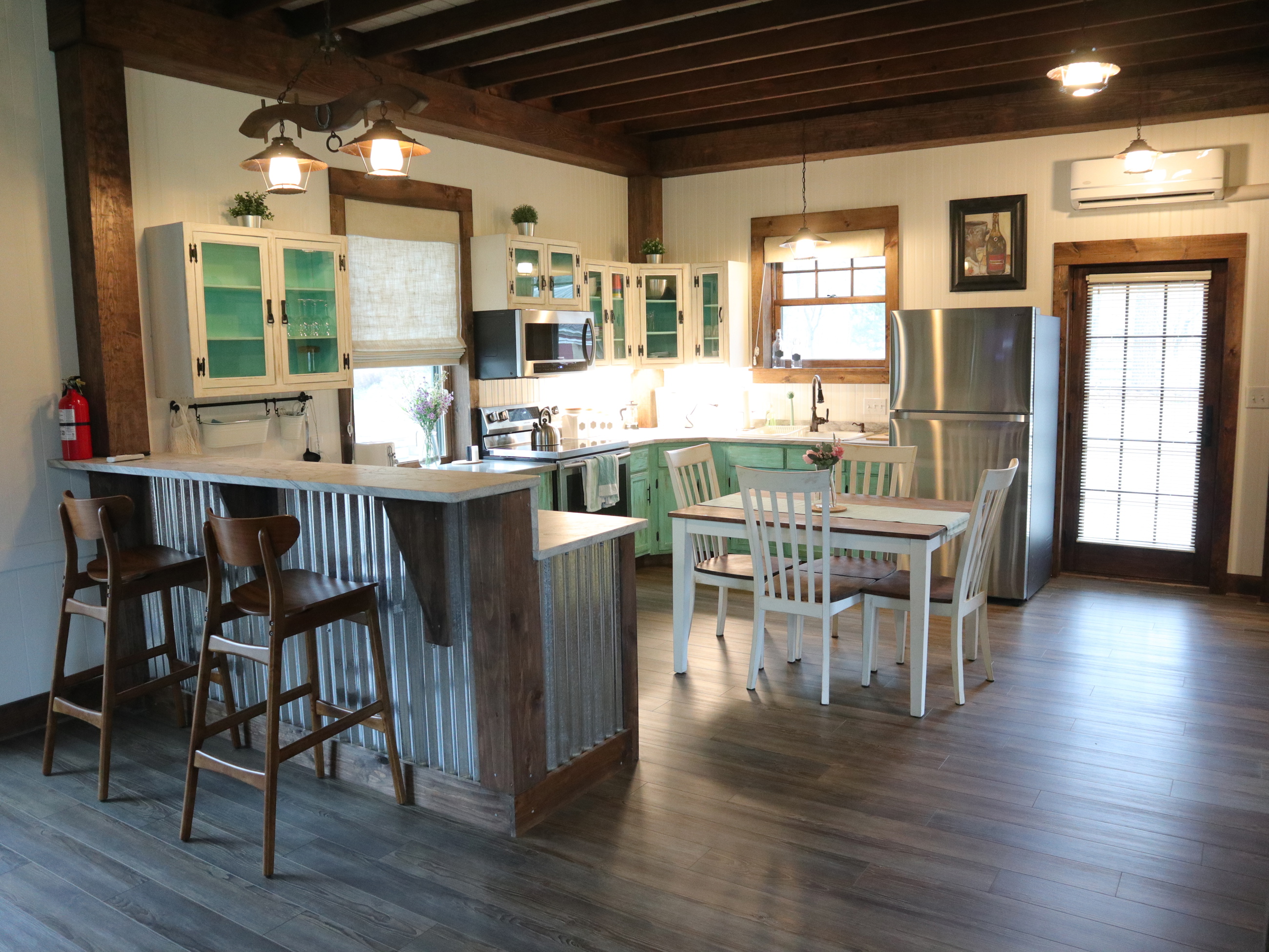 Cabinets with utensils, fridge-freezer, sink, microwave, 4 burner stove and oven, and coffee maker.
