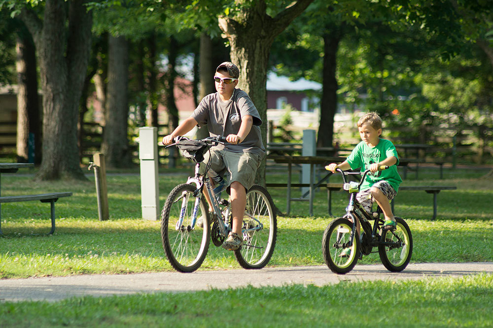 Deux enfants passent alentour du camping à vélo.